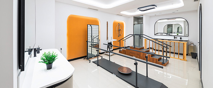 Heller Behandlungsraum von Medworld, weiß gehalten mit orangenen und schwarzen Akzenten.